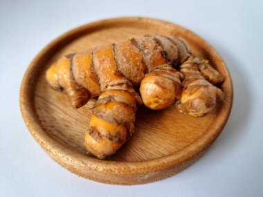 Servis panosundaki taze zerdeçal. Hareketli sarı rengiyle biliniyor. Aktif bileşik curkiminden geliyor. Zerdeçal, özellikle Güneydoğu Asya mutfağında lezzet ve renk artışı olarak yaygın olarak kullanılır.