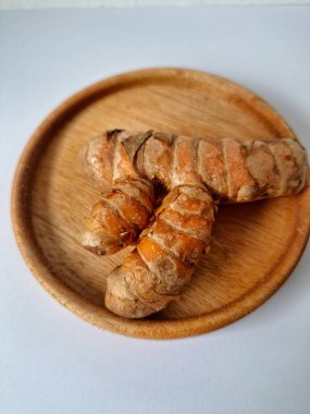 Servis panosundaki taze zerdeçal kökü. Zerdeçal öncelikle Asya mutfağında ve potansiyel sağlık yararları için yemek pişirmede bir baharat olarak kullanılır. Zemin baharatı ve taze kökler gibi çeşitli şekillerde de kullanılır.