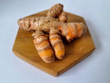 Servis panosundaki taze zerdeçal kökü. Zerdeçal öncelikle Asya mutfağında ve potansiyel sağlık yararları için yemek pişirmede bir baharat olarak kullanılır. Zemin baharatı ve taze kökler gibi çeşitli şekillerde de kullanılır.