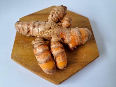 Servis panosundaki taze zerdeçal kökü. Zerdeçal öncelikle Asya mutfağında ve potansiyel sağlık yararları için yemek pişirmede bir baharat olarak kullanılır. Zemin baharatı ve taze kökler gibi çeşitli şekillerde de kullanılır.