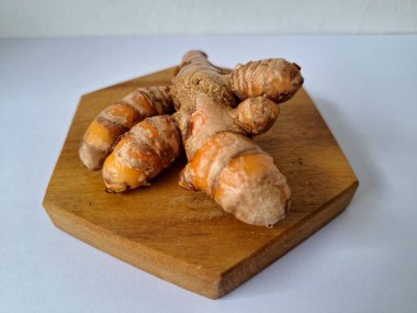 Servis panosundaki taze zerdeçal. Hareketli sarı rengiyle biliniyor. Aktif bileşik curkiminden geliyor. Zerdeçal, özellikle Güneydoğu Asya mutfağında lezzet ve renk artışı olarak yaygın olarak kullanılır.