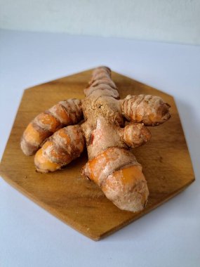 Servis panosundaki taze zerdeçal kökü. Zerdeçal öncelikle Asya mutfağında ve potansiyel sağlık yararları için yemek pişirmede bir baharat olarak kullanılır. Zemin baharatı ve taze kökler gibi çeşitli şekillerde de kullanılır.