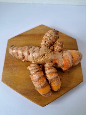 Servis panosundaki taze zerdeçal kökü. Zerdeçal öncelikle Asya mutfağında ve potansiyel sağlık yararları için yemek pişirmede bir baharat olarak kullanılır. Zemin baharatı ve taze kökler gibi çeşitli şekillerde de kullanılır.