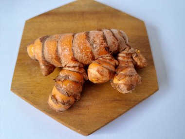 Servis panosundaki taze zerdeçal. Hareketli sarı rengiyle biliniyor. Aktif bileşik curkiminden geliyor. Zerdeçal, özellikle Güneydoğu Asya mutfağında lezzet ve renk artışı olarak yaygın olarak kullanılır.