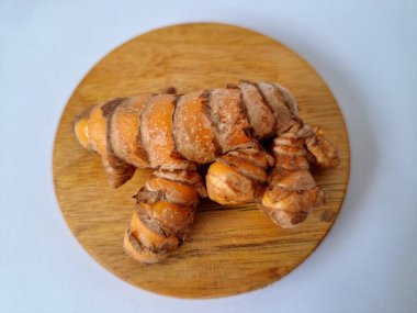 Servis panosundaki taze zerdeçal. Hareketli sarı rengiyle biliniyor. Aktif bileşik curkiminden geliyor. Zerdeçal, özellikle Güneydoğu Asya mutfağında lezzet ve renk artışı olarak yaygın olarak kullanılır.