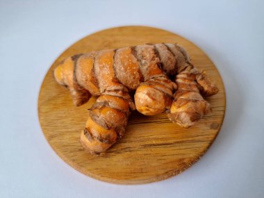 Servis panosundaki taze zerdeçal kökü. Zerdeçal öncelikle Asya mutfağında ve potansiyel sağlık yararları için yemek pişirmede bir baharat olarak kullanılır. Zemin baharatı ve taze kökler gibi çeşitli şekillerde de kullanılır.