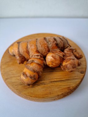 Servis panosundaki taze zerdeçal kökü. Zerdeçal öncelikle Asya mutfağında ve potansiyel sağlık yararları için yemek pişirmede bir baharat olarak kullanılır. Zemin baharatı ve taze kökler gibi çeşitli şekillerde de kullanılır.