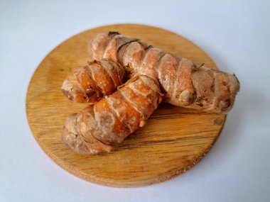 Servis panosundaki taze zerdeçal kökü. Zerdeçal öncelikle Asya mutfağında ve potansiyel sağlık yararları için yemek pişirmede bir baharat olarak kullanılır. Zemin baharatı ve taze kökler gibi çeşitli şekillerde de kullanılır.