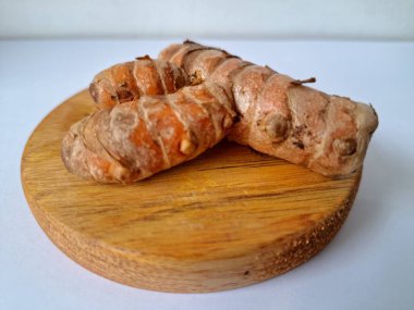 Servis panosundaki taze zerdeçal kökü. Zerdeçal öncelikle Asya mutfağında ve potansiyel sağlık yararları için yemek pişirmede bir baharat olarak kullanılır. Zemin baharatı ve taze kökler gibi çeşitli şekillerde de kullanılır.