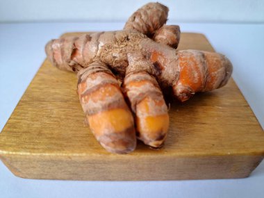 Servis panosundaki taze zerdeçal kökü. Zerdeçal öncelikle Asya mutfağında ve potansiyel sağlık yararları için yemek pişirmede bir baharat olarak kullanılır. Zemin baharatı ve taze kökler gibi çeşitli şekillerde de kullanılır.