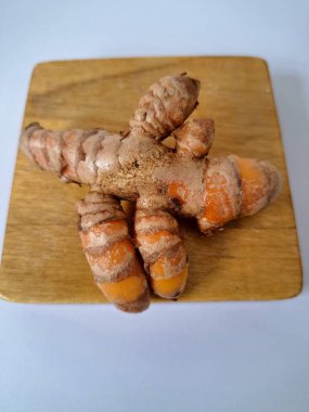 Servis panosundaki taze zerdeçal kökü. Zerdeçal öncelikle Asya mutfağında ve potansiyel sağlık yararları için yemek pişirmede bir baharat olarak kullanılır. Zemin baharatı ve taze kökler gibi çeşitli şekillerde de kullanılır.