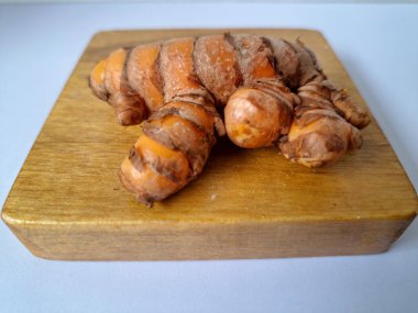 Servis panosundaki taze zerdeçal. Hareketli sarı rengiyle biliniyor. Aktif bileşik curkiminden geliyor. Zerdeçal, özellikle Güneydoğu Asya mutfağında lezzet ve renk artışı olarak yaygın olarak kullanılır.