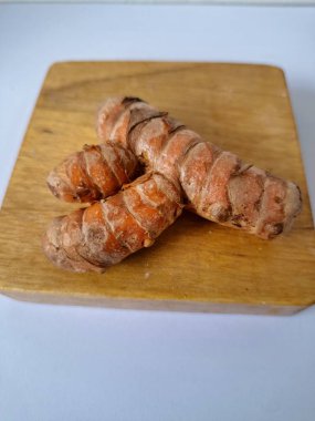 Servis panosundaki taze zerdeçal kökü. Zerdeçal öncelikle Asya mutfağında ve potansiyel sağlık yararları için yemek pişirmede bir baharat olarak kullanılır. Zemin baharatı ve taze kökler gibi çeşitli şekillerde de kullanılır.