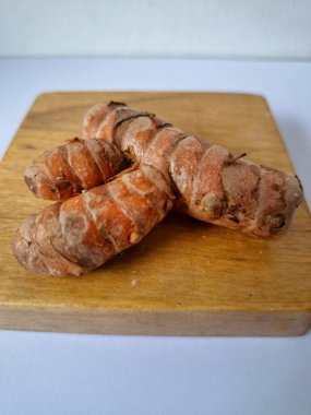 Servis panosundaki taze zerdeçal kökü. Zerdeçal öncelikle Asya mutfağında ve potansiyel sağlık yararları için yemek pişirmede bir baharat olarak kullanılır. Zemin baharatı ve taze kökler gibi çeşitli şekillerde de kullanılır.