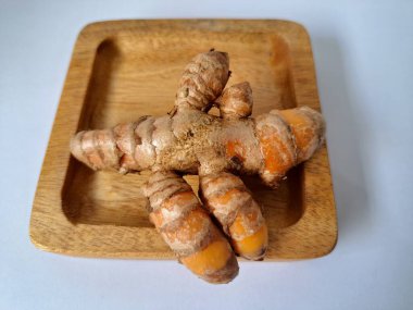 Servis panosundaki taze zerdeçal. Hareketli sarı rengiyle biliniyor. Aktif bileşik curkiminden geliyor. Zerdeçal, özellikle Güneydoğu Asya mutfağında lezzet ve renk artışı olarak yaygın olarak kullanılır.