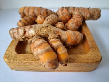 Servis panosundaki taze zerdeçal. Hareketli sarı rengiyle biliniyor. Aktif bileşik curkiminden geliyor. Zerdeçal, özellikle Güneydoğu Asya mutfağında lezzet ve renk artışı olarak yaygın olarak kullanılır.