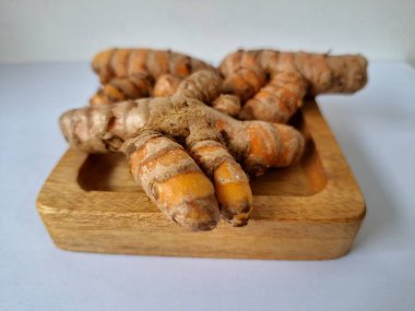 Servis panosundaki taze zerdeçal kökü. Zerdeçal öncelikle Asya mutfağında ve potansiyel sağlık yararları için yemek pişirmede bir baharat olarak kullanılır. Zemin baharatı ve taze kökler gibi çeşitli şekillerde de kullanılır.