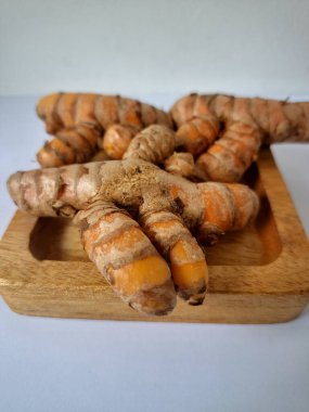 Servis panosundaki taze zerdeçal. Hareketli sarı rengiyle biliniyor. Aktif bileşik curkiminden geliyor. Zerdeçal, özellikle Güneydoğu Asya mutfağında lezzet ve renk artışı olarak yaygın olarak kullanılır.