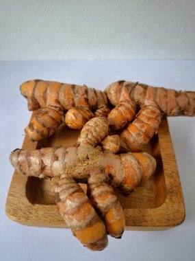 Servis panosundaki taze zerdeçal kökü. Zerdeçal öncelikle Asya mutfağında ve potansiyel sağlık yararları için yemek pişirmede bir baharat olarak kullanılır. Zemin baharatı ve taze kökler gibi çeşitli şekillerde de kullanılır.