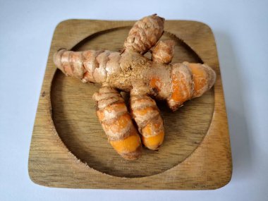 Servis panosundaki taze zerdeçal. Hareketli sarı rengiyle biliniyor. Aktif bileşik curkiminden geliyor. Zerdeçal, özellikle Güneydoğu Asya mutfağında lezzet ve renk artışı olarak yaygın olarak kullanılır.