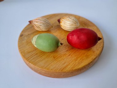 Tahtada Noel ağacı tohumu. Noel tohumlarını filizlendirmek ve hızlı büyümek nispeten kolaydır. Noel mevsiminde olgunlaşan parlak kırmızı meyveleriyle tanınırlar.