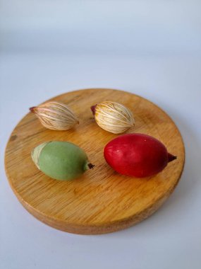 Tahtada Noel ağacı tohumu. Noel tohumlarını filizlendirmek ve hızlı büyümek nispeten kolaydır. Noel mevsiminde olgunlaşan parlak kırmızı meyveleriyle tanınırlar.