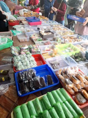 Müşteriler geleneksel Endonezya atıştırmalık dükkanından geleneksel Endonezya atıştırmalıkları almak için kuyruğa giriyorlar