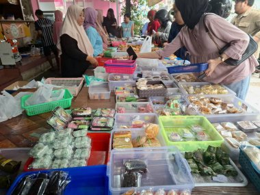 Müşteriler geleneksel Endonezya atıştırmalık dükkanından geleneksel Endonezya atıştırmalıkları almak için kuyruğa giriyorlar