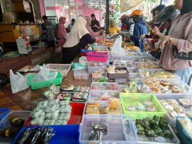 Müşteriler geleneksel Endonezya atıştırmalık dükkanından geleneksel Endonezya atıştırmalıkları almak için kuyruğa giriyorlar