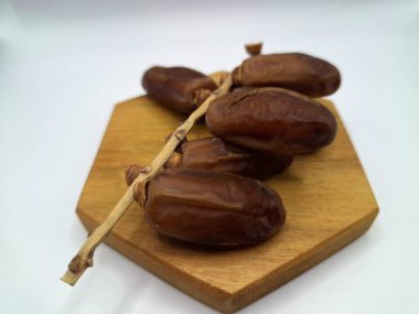 Servis panosundaki tarihler. Meyveleri salkımlı, salkımlı, salkımlı hurma ağaçları arasındadırlar. Genellikle doğal tatlılıklarıyla bilinirler ve genellikle atıştırmalık olarak ya da çeşitli tariflerde kullanılırlar.