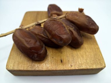 Servis panosundaki tarihler. Meyveleri salkımlı, salkımlı, salkımlı hurma ağaçları arasındadırlar. Genellikle doğal tatlılıklarıyla bilinirler ve genellikle atıştırmalık olarak ya da çeşitli tariflerde kullanılırlar.