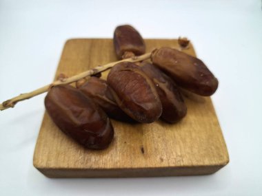 Servis panosundaki tarihler. Meyveleri salkımlı, salkımlı, salkımlı hurma ağaçları arasındadırlar. Genellikle doğal tatlılıklarıyla bilinirler ve genellikle atıştırmalık olarak ya da çeşitli tariflerde kullanılırlar.