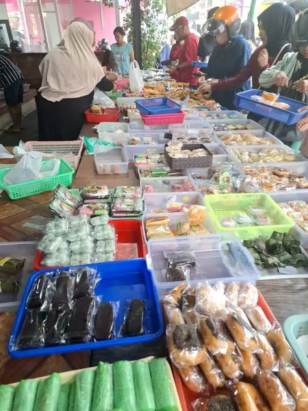 Müşteriler geleneksel Endonezya atıştırmalık dükkanından geleneksel Endonezya atıştırmalıkları almak için kuyruğa giriyorlar