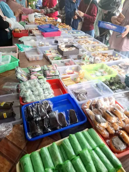 Müşteriler geleneksel Endonezya atıştırmalık dükkanından geleneksel Endonezya atıştırmalıkları almak için kuyruğa giriyorlar