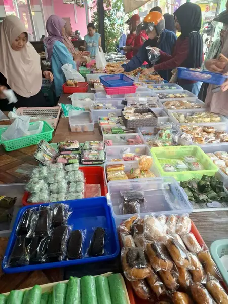 Müşteriler geleneksel Endonezya atıştırmalık dükkanından geleneksel Endonezya atıştırmalıkları almak için kuyruğa giriyorlar