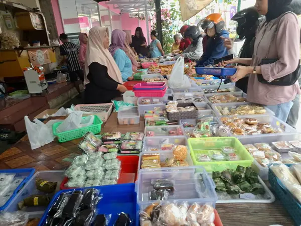 Müşteriler geleneksel Endonezya atıştırmalık dükkanından geleneksel Endonezya atıştırmalıkları almak için kuyruğa giriyorlar