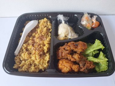 Endonezya 'dan geleneksel beslenme çantası. Bu beslenme çantası genellikle sarı pilav içerir ve kızarmış tavuk, kraker, marul ve Endonezya biber sosuyla servis edilir.