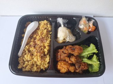 Endonezya 'dan geleneksel beslenme çantası. Bu beslenme çantası genellikle sarı pilav içerir ve kızarmış tavuk, kraker, marul ve Endonezya biber sosuyla servis edilir.