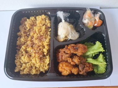 Endonezya 'dan geleneksel beslenme çantası. Bu beslenme çantası genellikle sarı pilav içerir ve kızarmış tavuk, kraker, marul ve Endonezya biber sosuyla servis edilir.