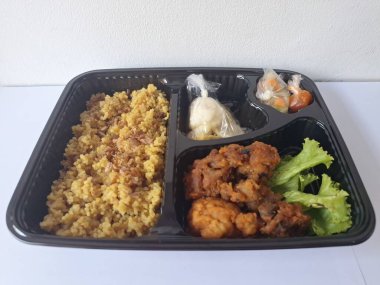 Endonezya 'dan geleneksel beslenme çantası. Bu beslenme çantası genellikle sarı pilav içerir ve kızarmış tavuk, kraker, marul ve Endonezya biber sosuyla servis edilir.