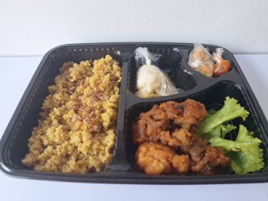 Endonezya 'dan geleneksel beslenme çantası. Bu beslenme çantası genellikle sarı pilav içerir ve kızarmış tavuk, kraker, marul ve Endonezya biber sosuyla servis edilir.