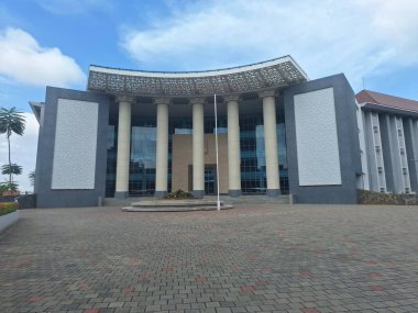 Mavi gökyüzünün altındaki görkemli bir binanın dışı.