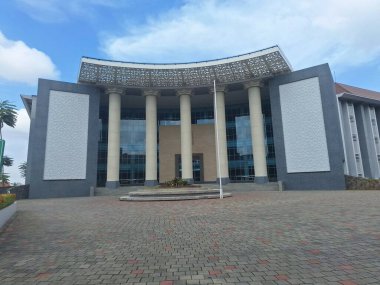 Mavi gökyüzünün altındaki görkemli bir binanın dışı.