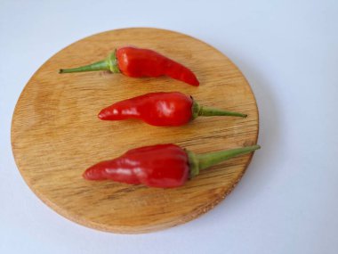 Yuvarlak tahta üzerinde kırmızı biber. Acı bir tadı olan ve sıklıkla yemek ve tıpta kullanılan bir biber türüdür. Bu kırmızı biber ince şekli, parlak kırmızı rengi ve yüksek seviye...