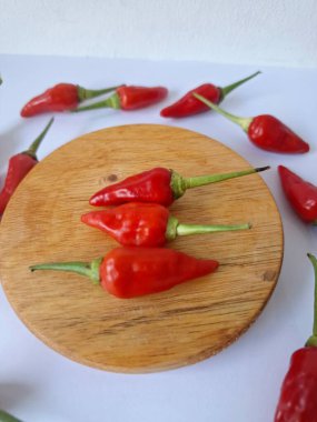 Yuvarlak tahta üzerinde kırmızı biber. Acı bir tadı olan ve sıklıkla yemek ve tıpta kullanılan bir biber türüdür. Bu kırmızı biber ince şekli, parlak kırmızı rengi ve yüksek seviye...