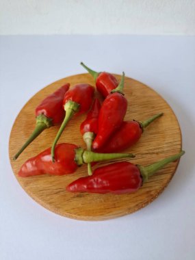 Yuvarlak tahta üzerinde kırmızı biber. Acı bir tadı olan ve sıklıkla yemek ve tıpta kullanılan bir biber türüdür. Bu kırmızı biber ince şekli, parlak kırmızı rengi ve yüksek seviye...
