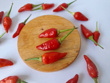 Yuvarlak tahta üzerinde kırmızı biber. Acı bir tadı olan ve sıklıkla yemek ve tıpta kullanılan bir biber türüdür. Bu kırmızı biber ince şekli, parlak kırmızı rengi ve yüksek seviye...