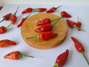 Yuvarlak tahta üzerinde kırmızı biber. Acı bir tadı olan ve sıklıkla yemek ve tıpta kullanılan bir biber türüdür. Bu kırmızı biber ince şekli, parlak kırmızı rengi ve yüksek seviye...