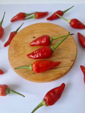 Yuvarlak tahta üzerinde kırmızı biber. Acı bir tadı olan ve sıklıkla yemek ve tıpta kullanılan bir biber türüdür. Bu kırmızı biber ince şekli, parlak kırmızı rengi ve yüksek seviye...
