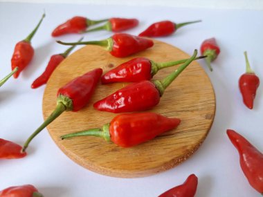 Yuvarlak tahta üzerinde kırmızı biber. Acı bir tadı olan ve sıklıkla yemek ve tıpta kullanılan bir biber türüdür. Bu kırmızı biber ince şekli, parlak kırmızı rengi ve yüksek seviye...